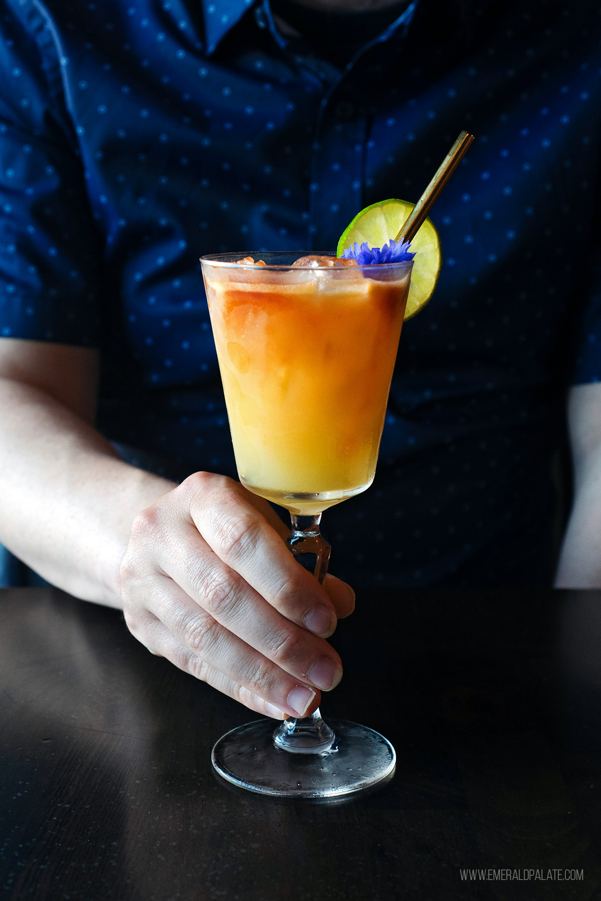 man holding a fancy cocktail from one of the best Olympia restaurants