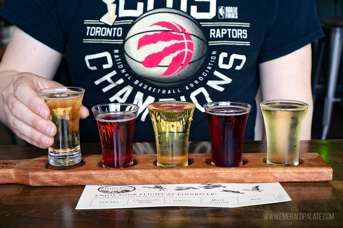 man picking up cider from a cider flight, one of the best things to do in Olympia, WA