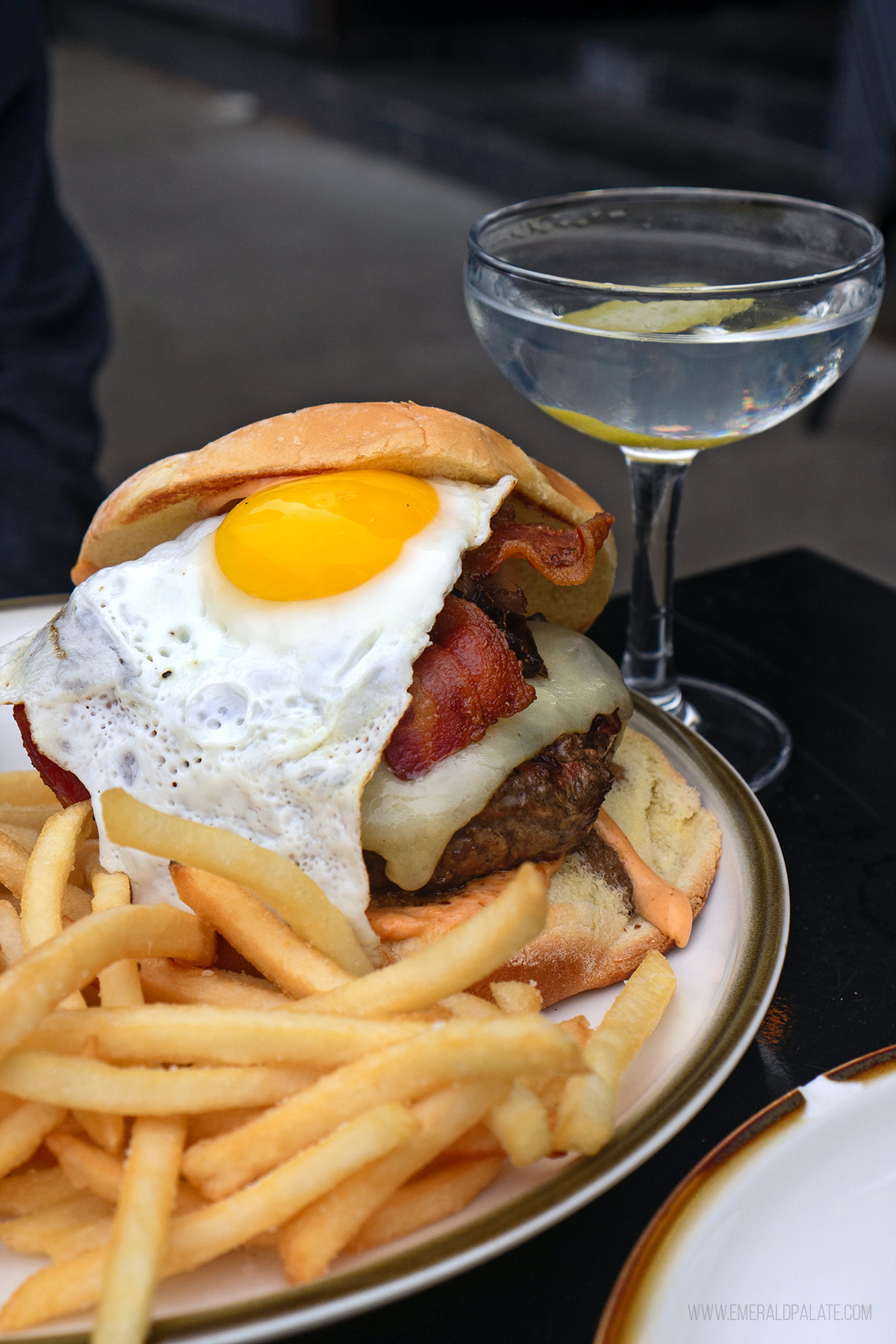 larger burger in Seattle topped with an egg and served with fries