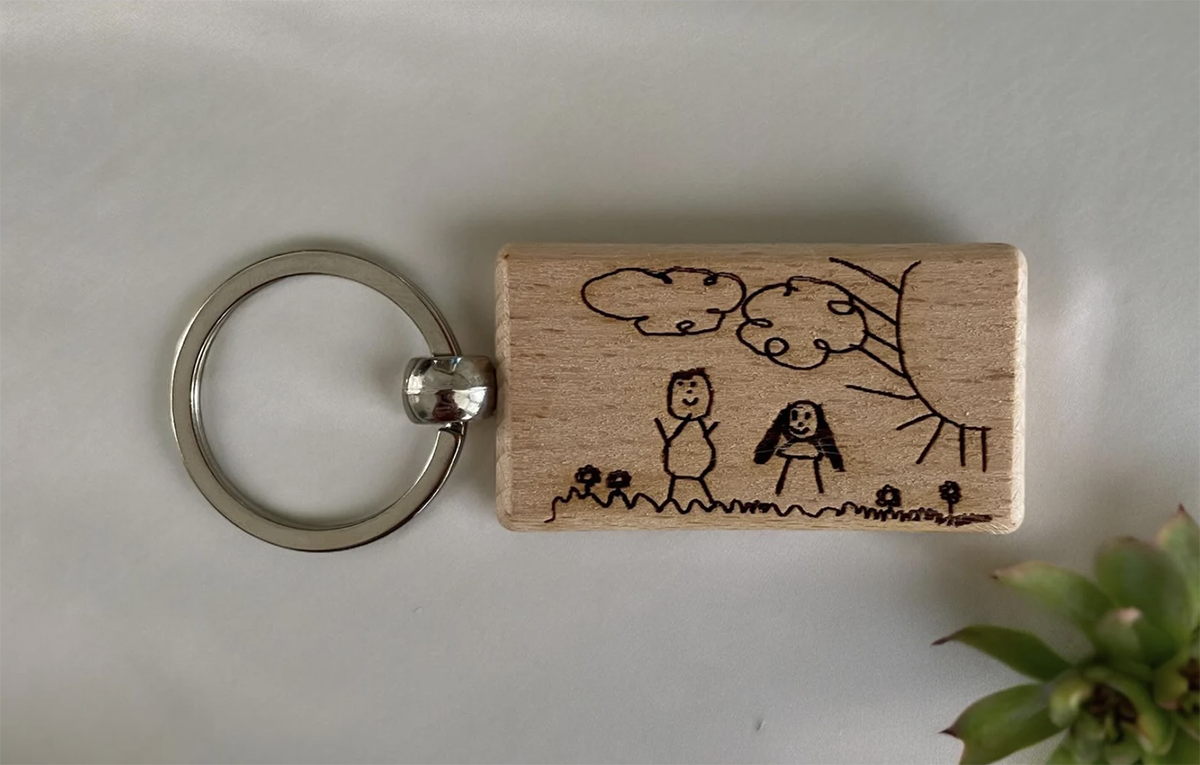 A keychain with a child's drawing engraved on it, one of the most unique travel gifts