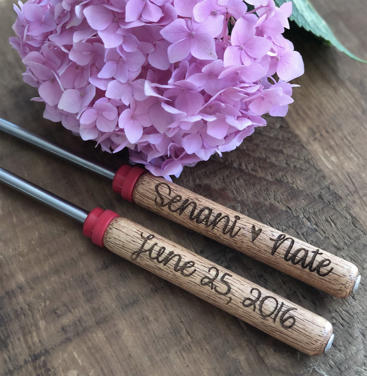 Two custom s'mores sticks each engraved with two names and a date