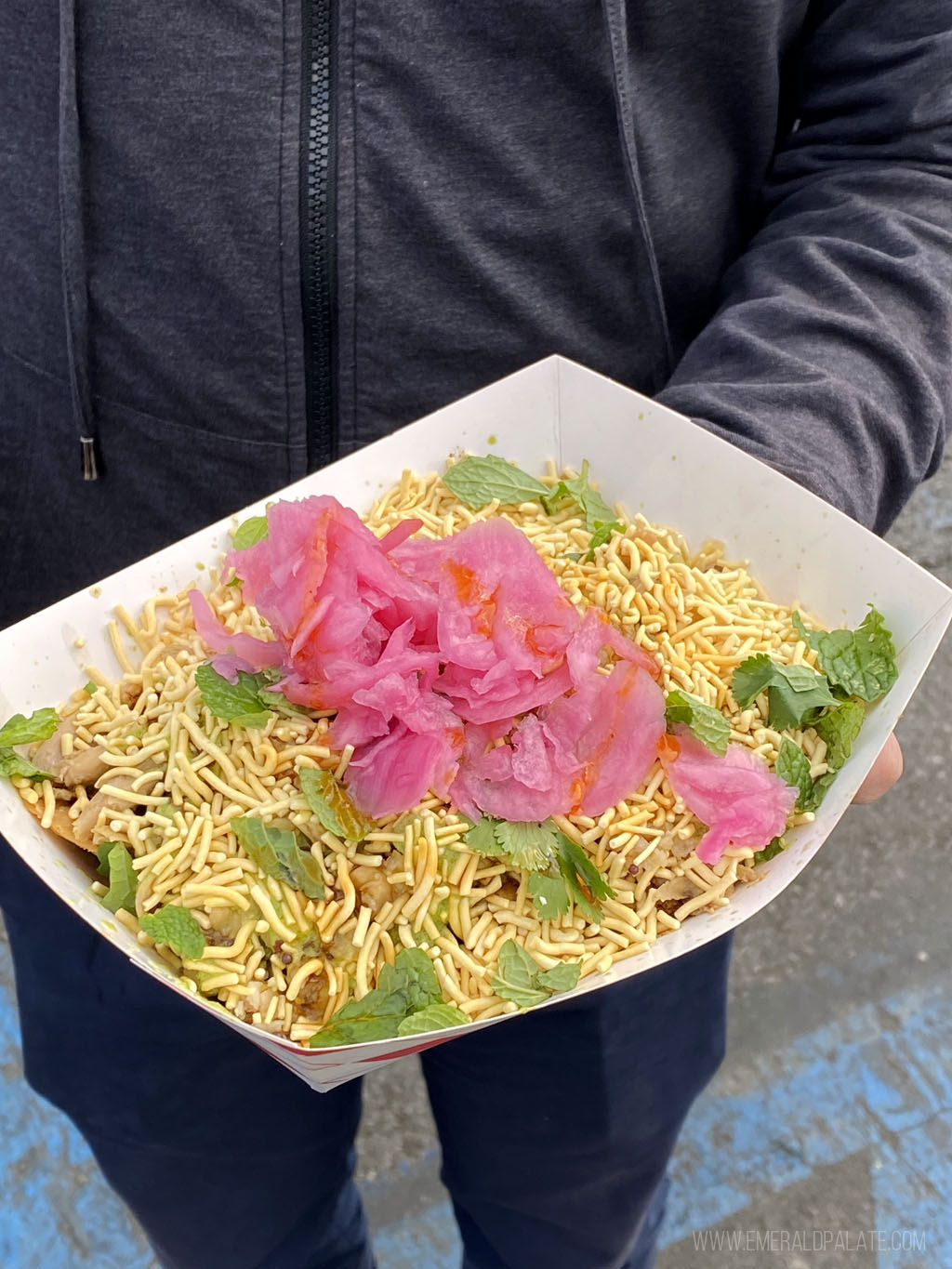 person holding a takeout container of chaat nachos from Smorgasburg LA