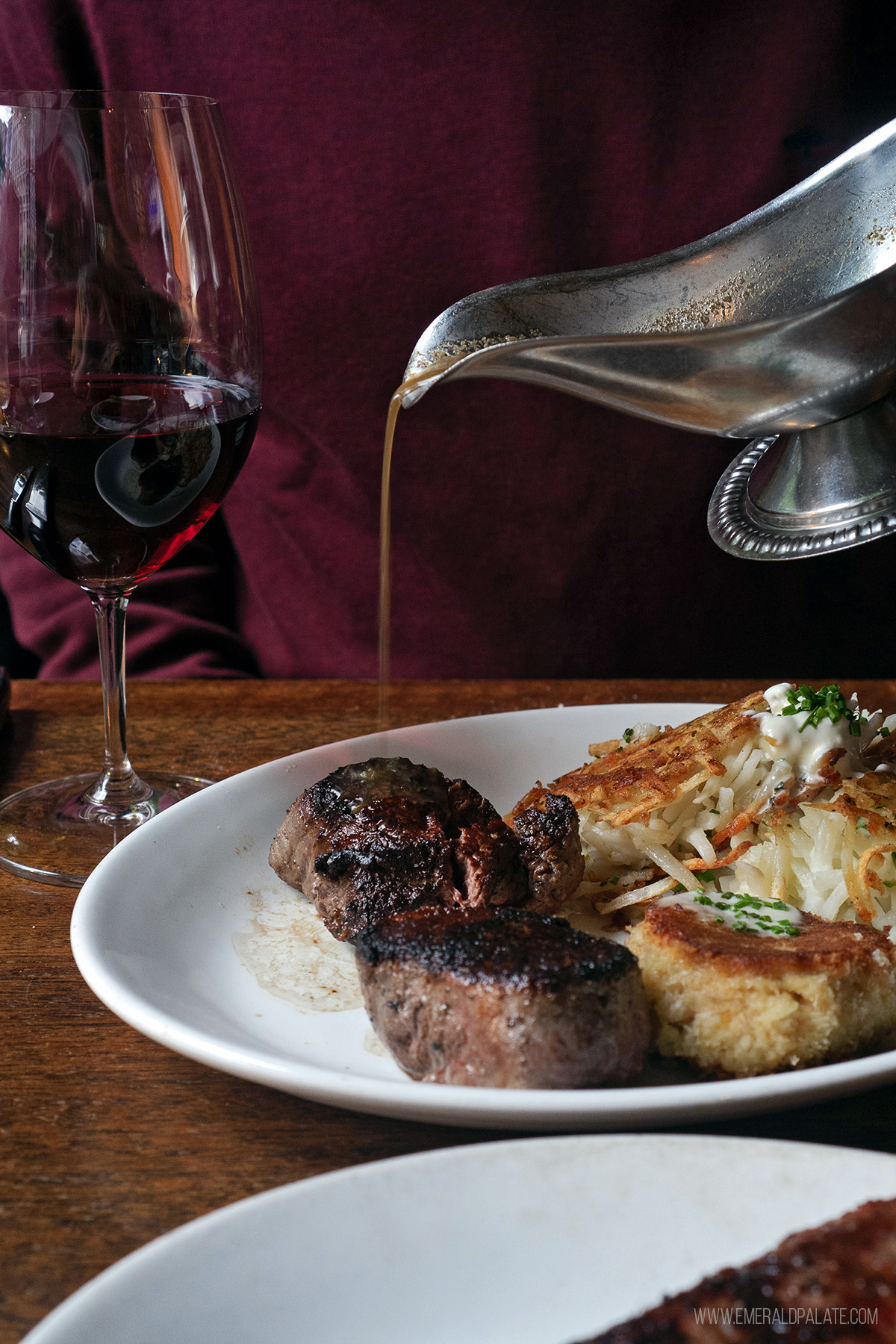 person pouring jus over filet mignon at one of the best steak restaurants in Seattle