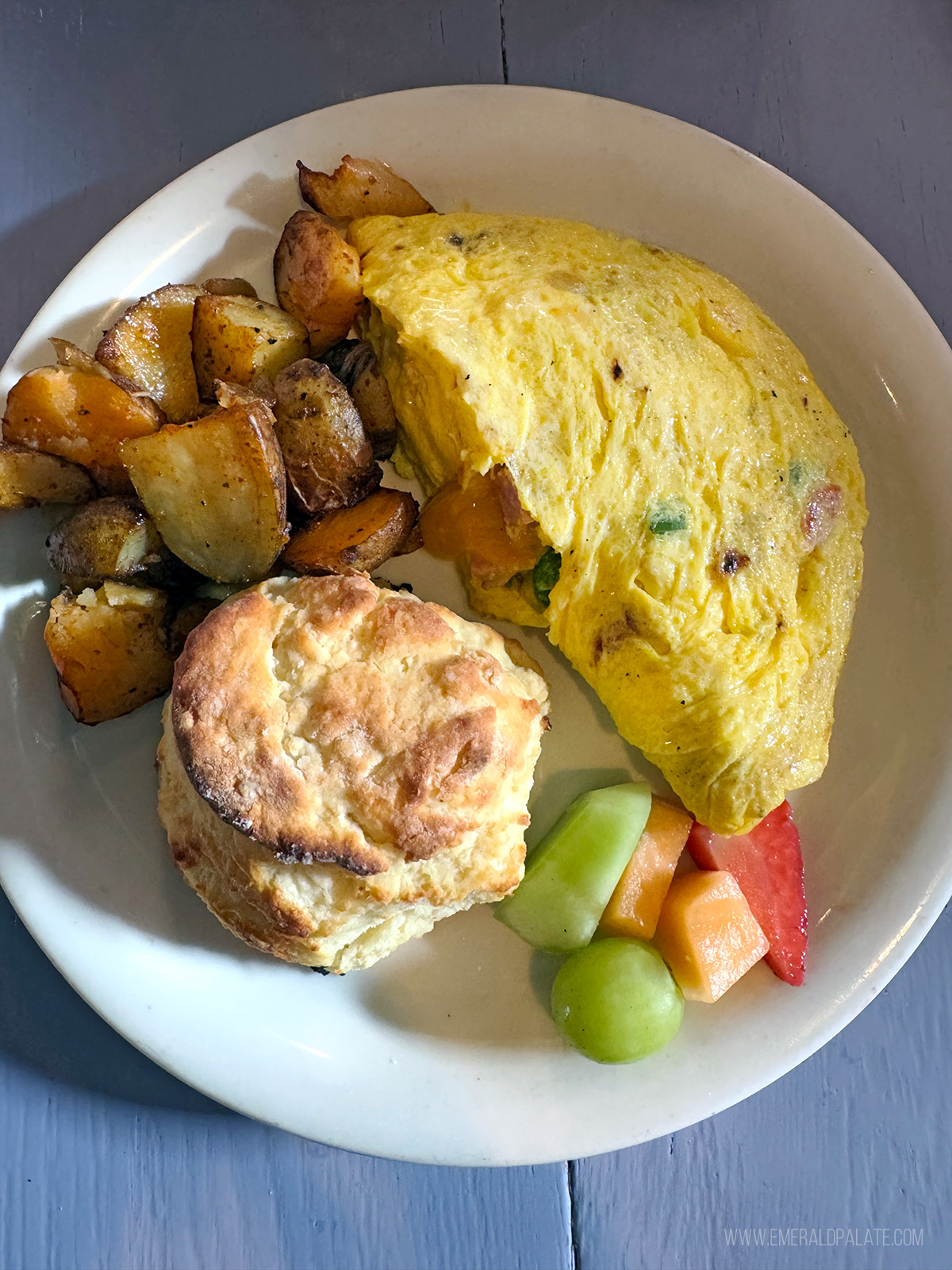 best breakfast in Seattle: an omelet, fruit, biscuit, and home fries