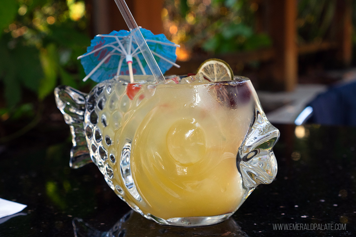 cocktail in a large fish glass with an umbrella