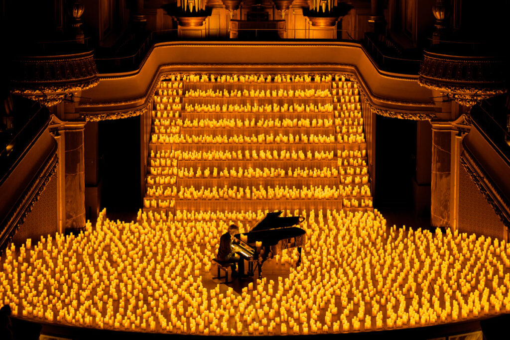 pianist surrounded by candles on a stage