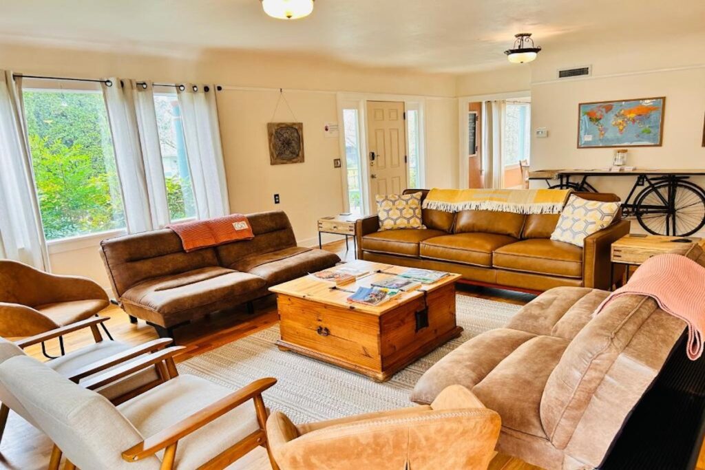 Living room with couches, chairs, and a coffee table at the Riverpath Inn in Eugene