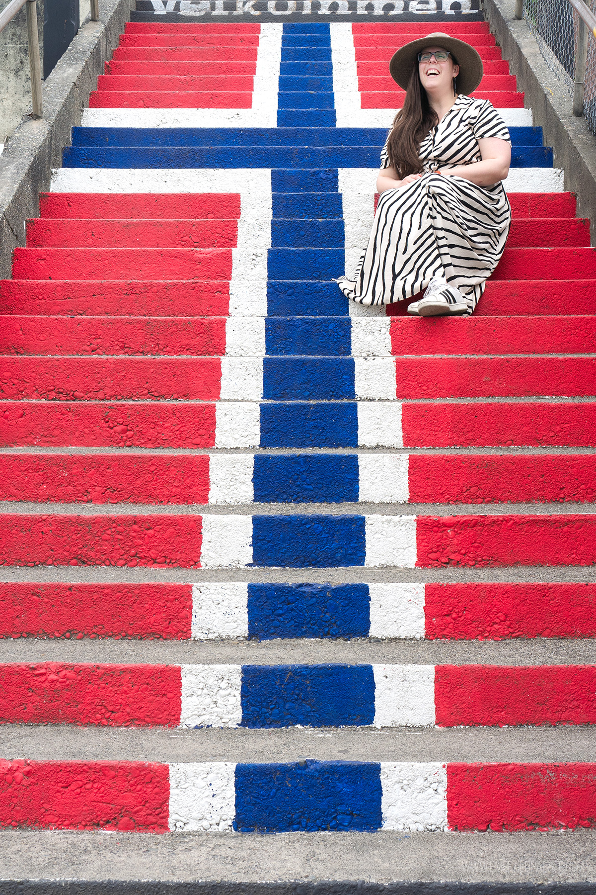 woman sitting on stairs painting to be the Norwegian flag