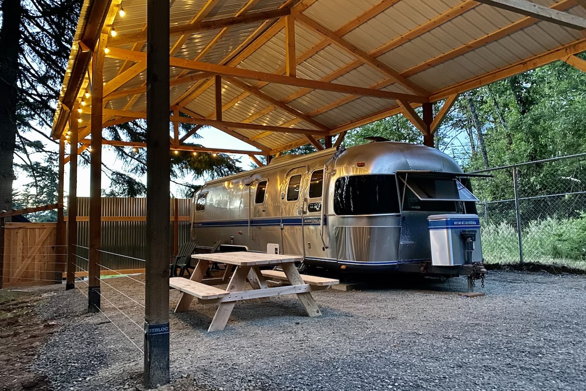 Outside view of a an Airstream trailer under a carport, one of the best glamping spots in Oregon wine country