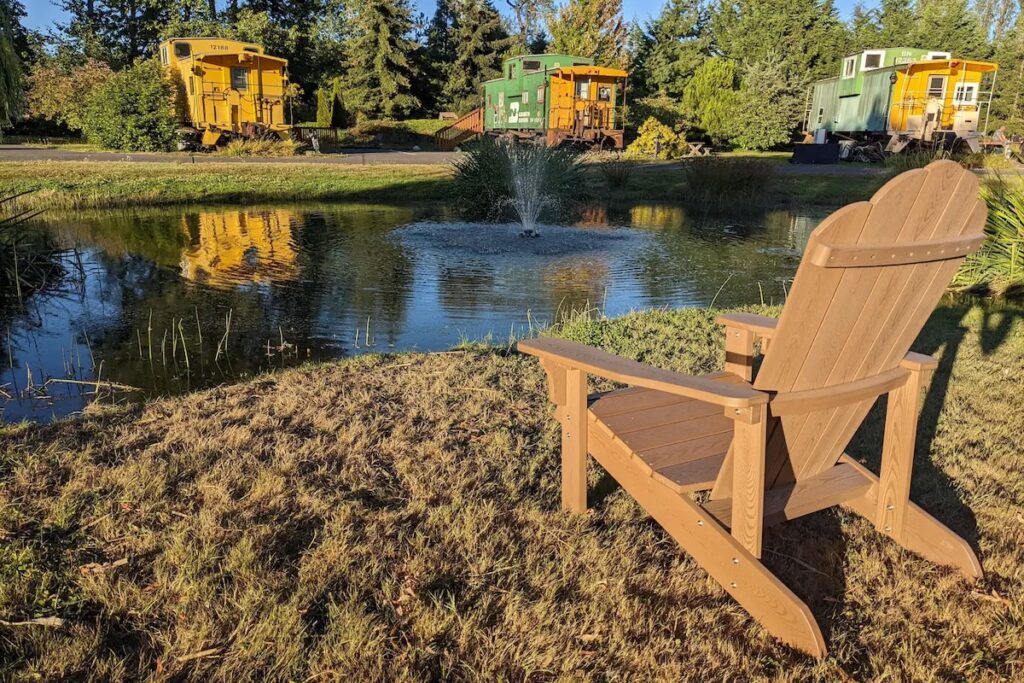 An Adirondack chair on the water overlooking private cabooses at the Olympic Railway Inn in Sequim