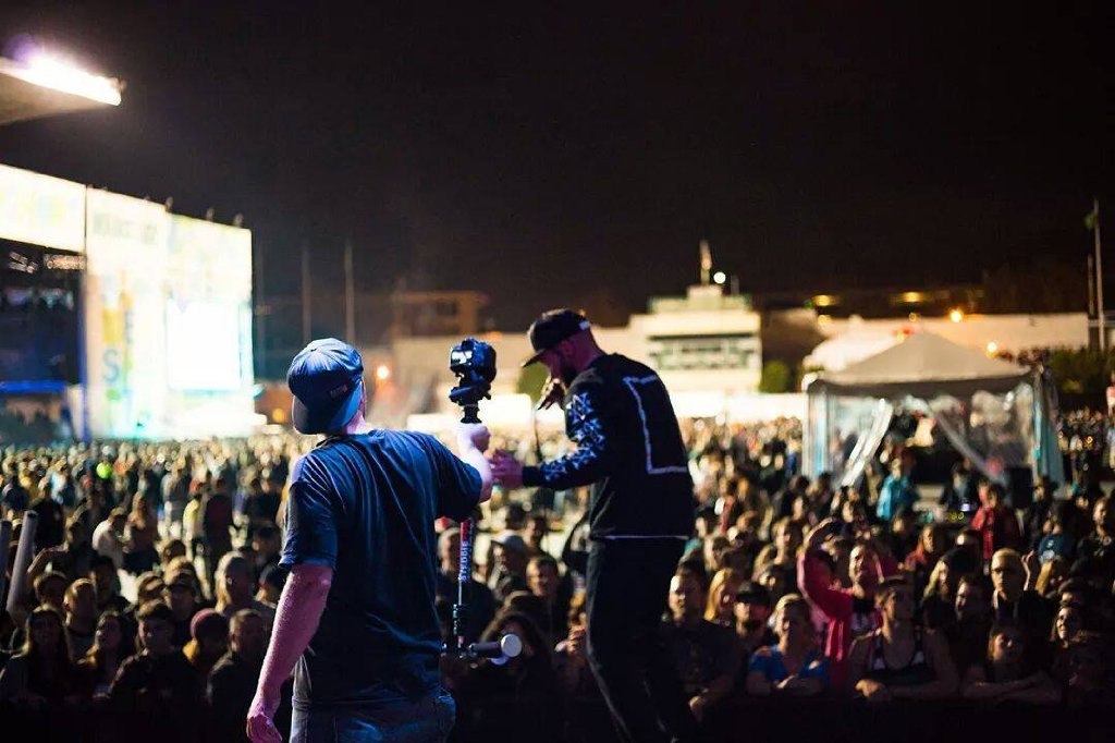 person filming a musician at Bumbershoot, one of the best things to do in Seattle in September