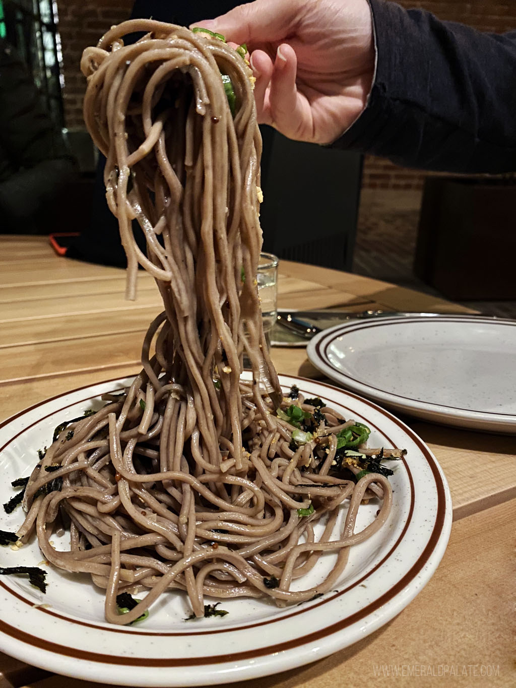 person pulling noodles from a unique LA restaurant