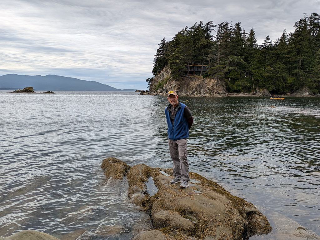 Personal travel planner client posing on a rock in water