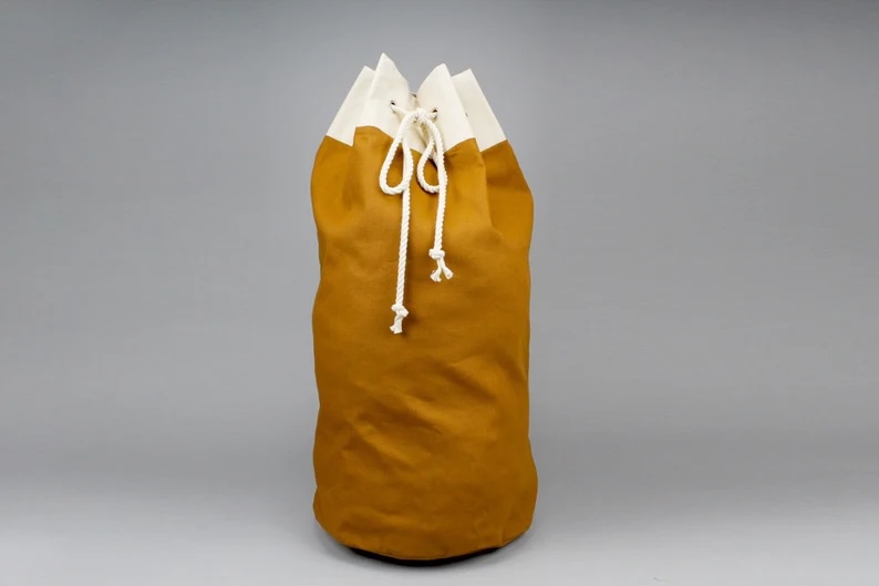 A brown and white canvas laundry bag with white string