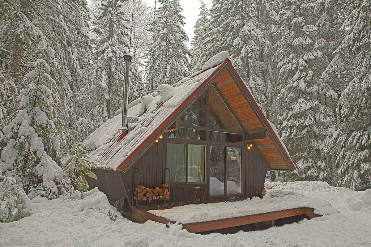 a-frame cabin nestled in snow covered forest