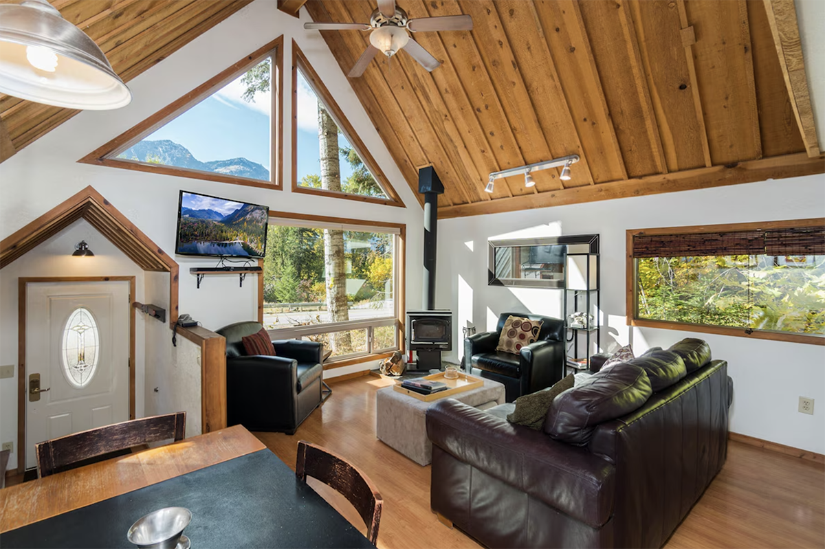 living room inside an a-frame cabin with vaulted wood ceilings