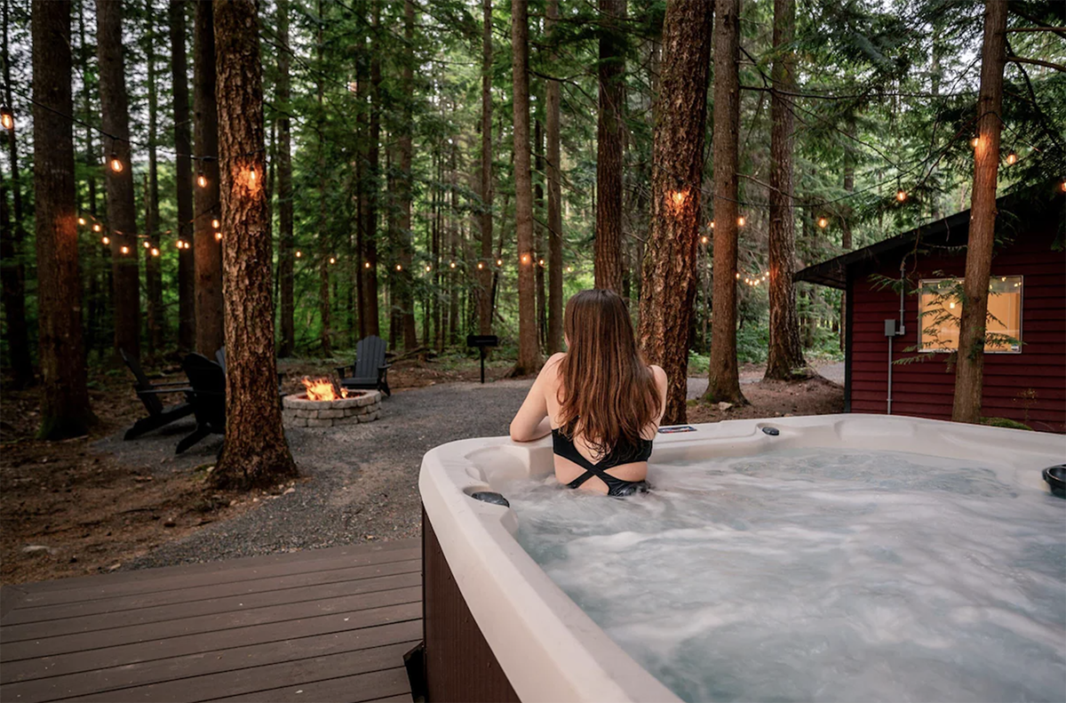 woman soaking in a hot tub at a cabin near one of the best ski resorts in Washington