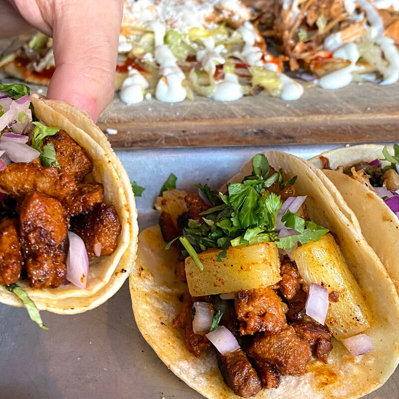 person picking up street tacos from one of the best restaurants in Beacon Hill, Seattle Washington