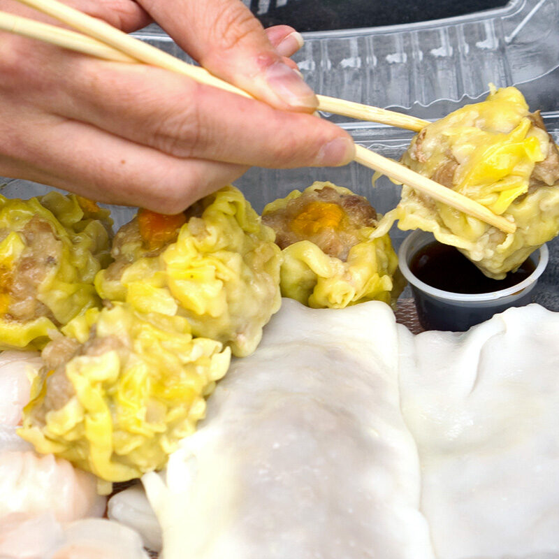 person eating dim sum takeout from one of the Best Restaurants in the Seattle International District