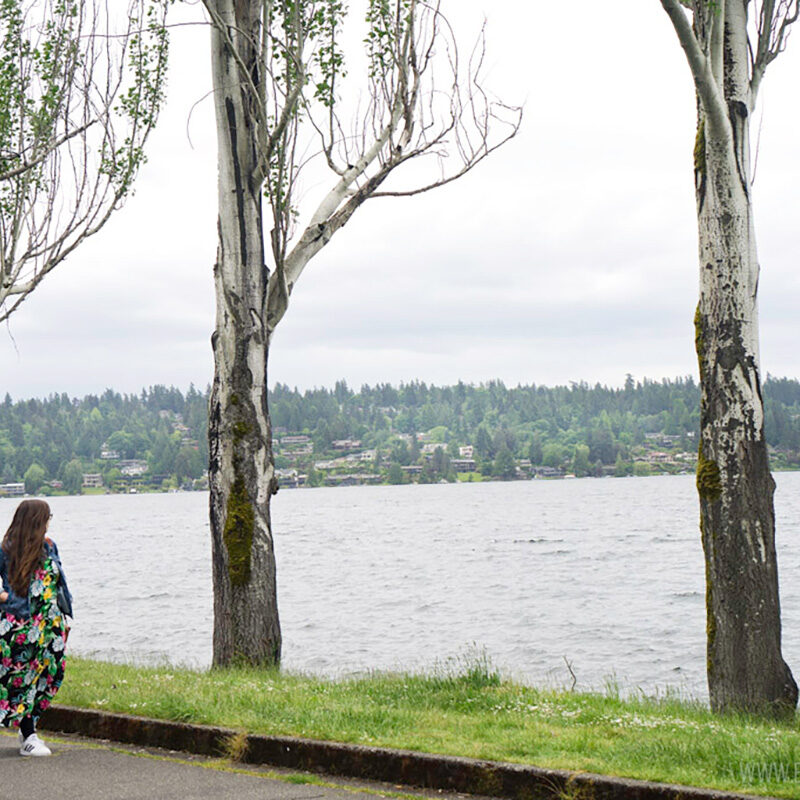 woman walking along a trail in a park, one of the best things to do alone in Seattle