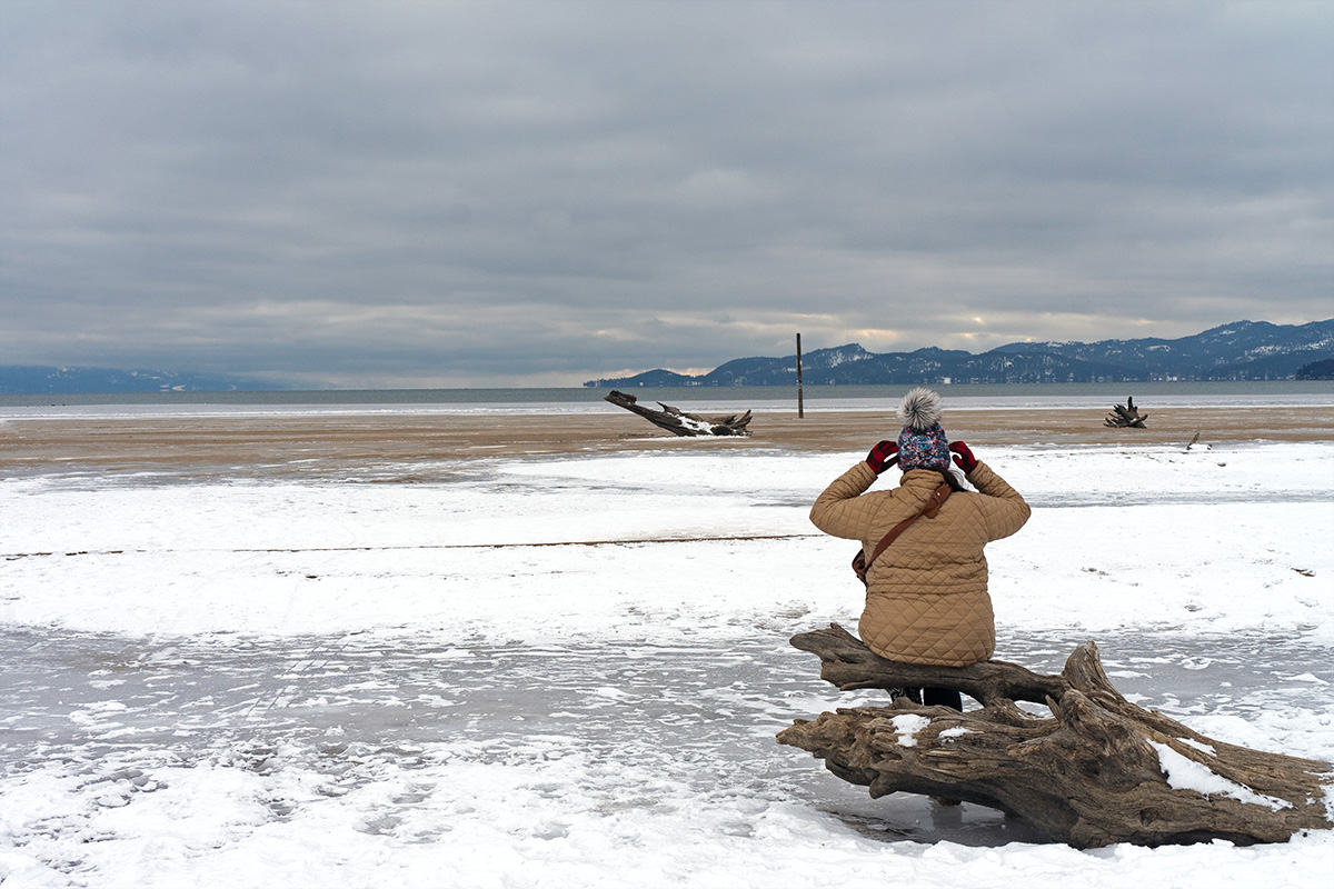 Woman enjoying a beach in winter, one of the best things to do in Kalispell Montana