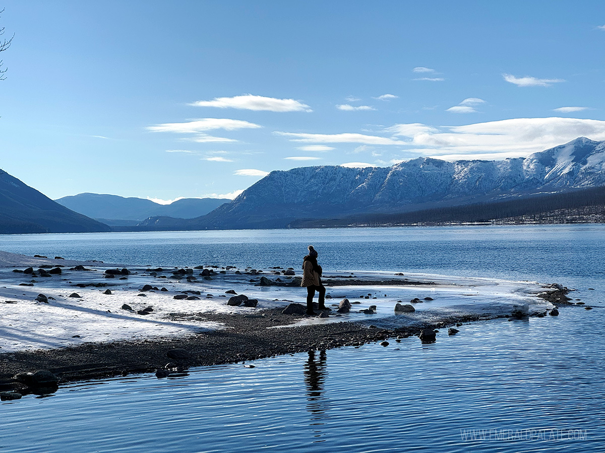 woman walking on a beach at Lake McDonald, one of the best things to do in Kalispell Montana